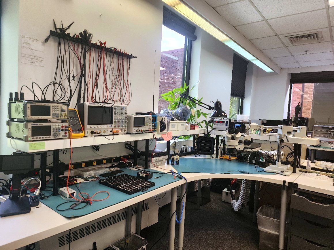 ARG electronics lab bench with oscilloscopes, DMMs, and bench instruments